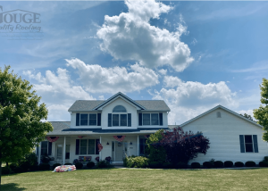 large residential home with green grass and gouge logo in upper left corner