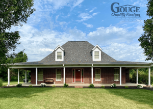 front view of residential brick home, clear blue sky in background and gouge logo in upper right corner