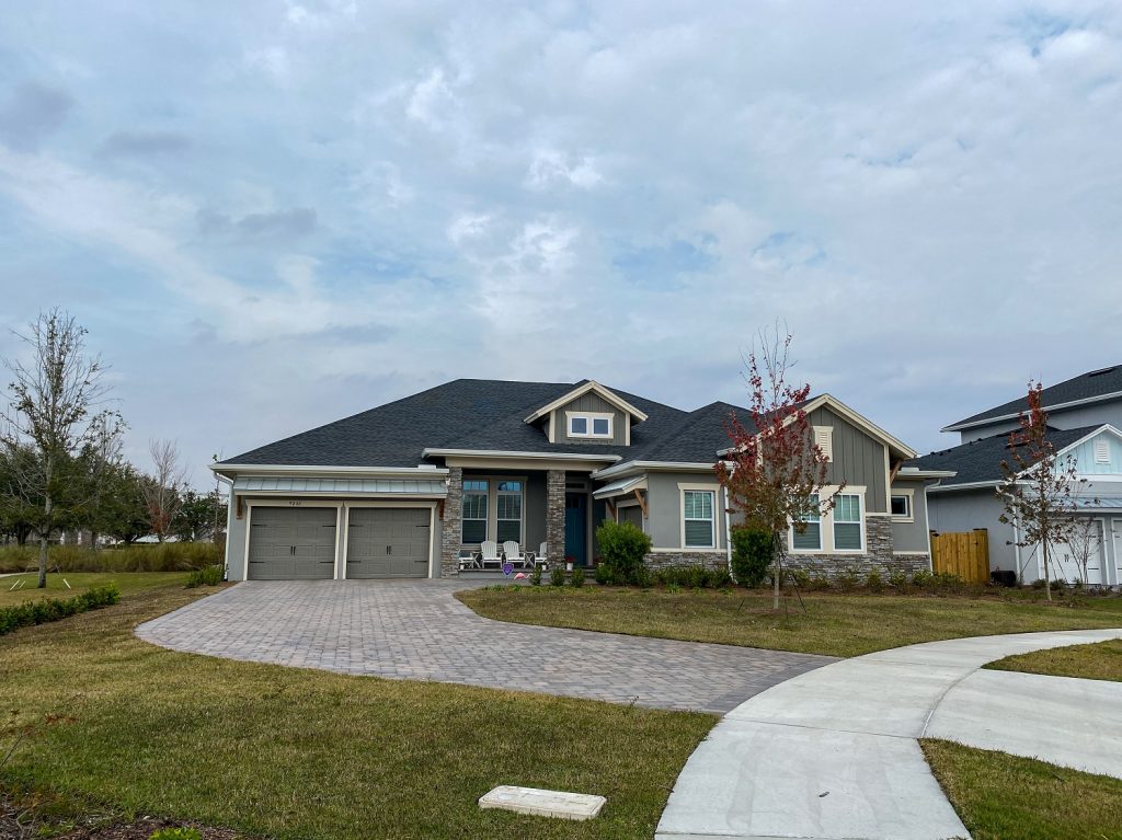 A luxury house with dark gray siding and charcoal roof color combinations