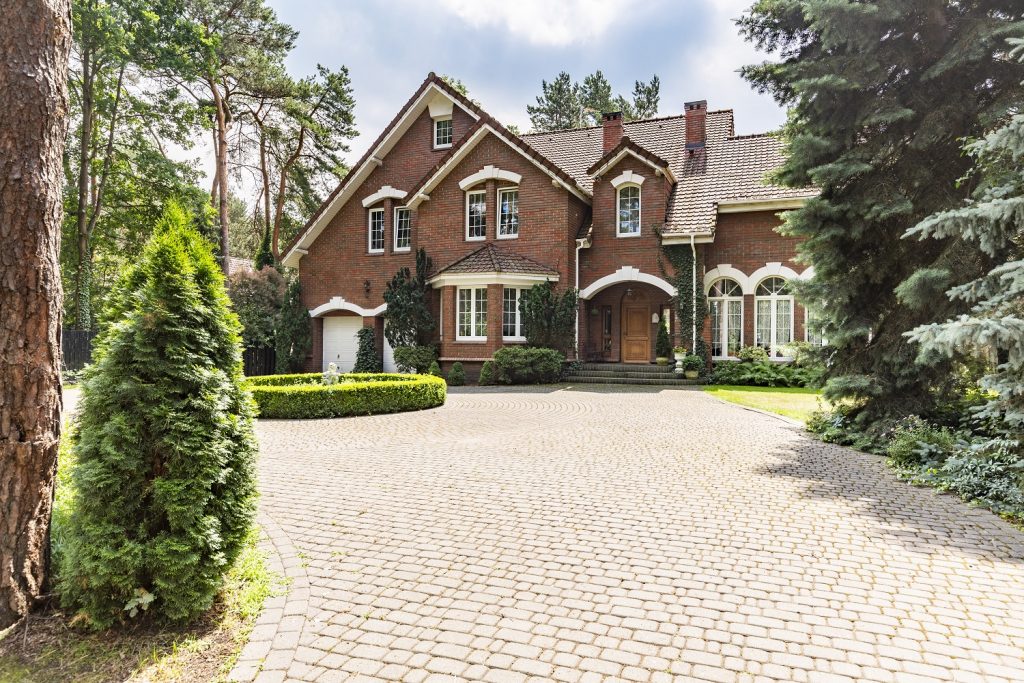 red brick and brown roof color combinations English design mansion surrounded by old trees 