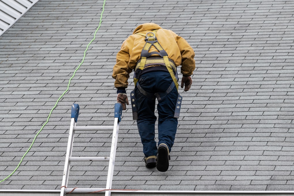 man completing roof inspection for roof claim