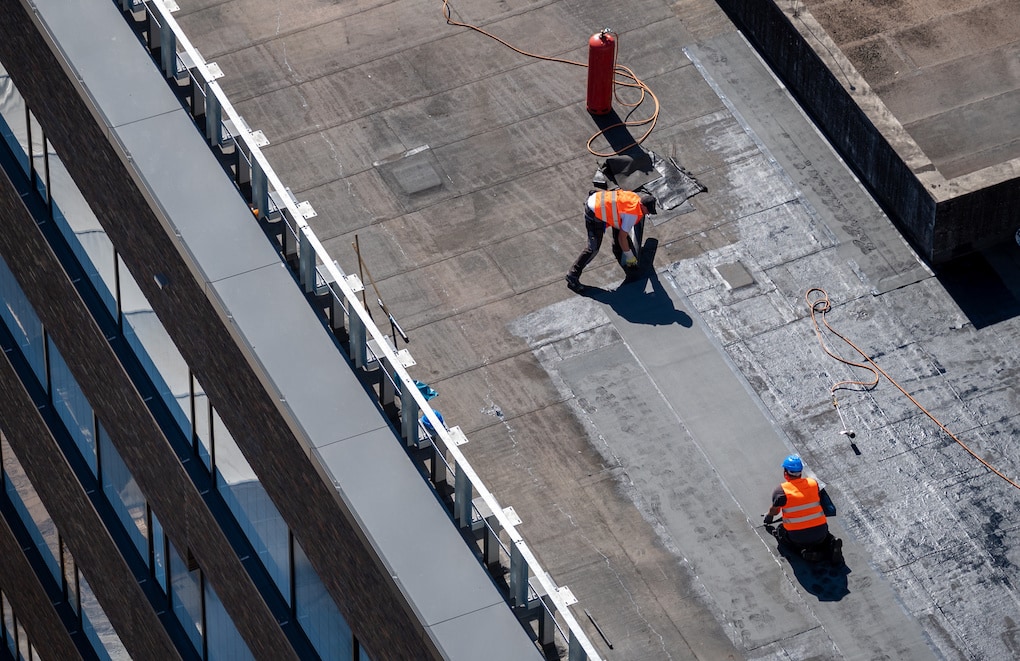 Birds eye view of a flat roof installation construction site. 