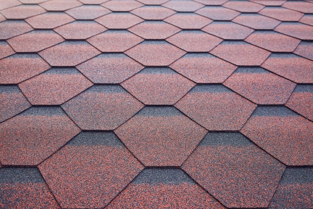 close up of red composite shingles, one of the most popular roof replacement options