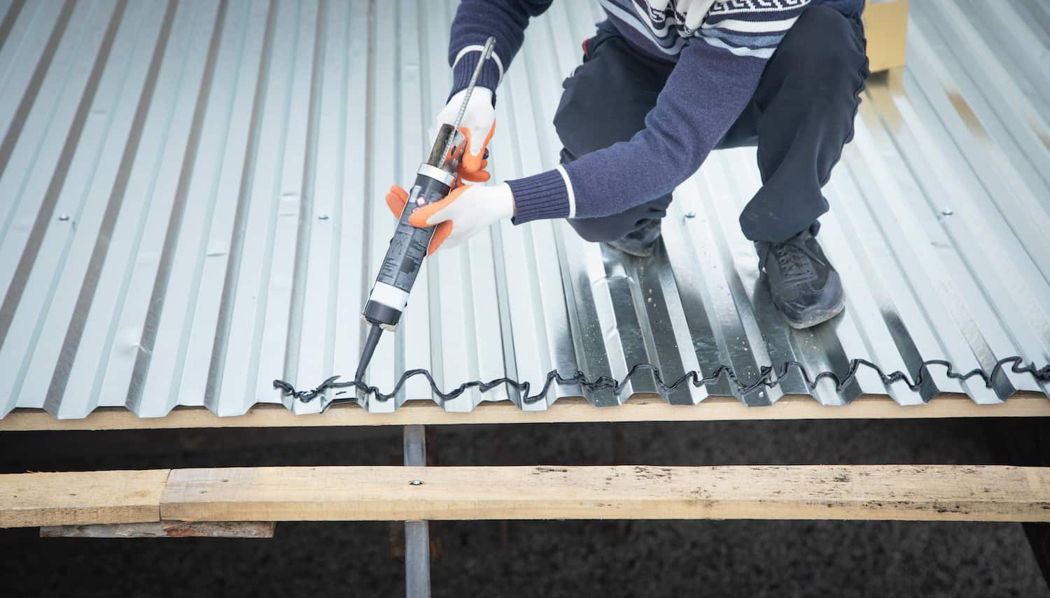 metal roof sealant worker